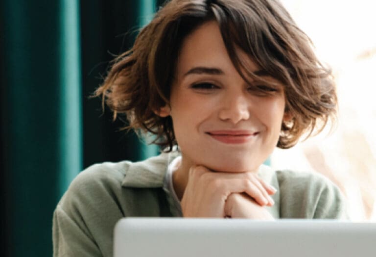 woman with short hair on computer smiling